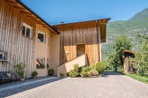 Ein Holzhaus mit Treppe, Blumentöpfen und einer Bank.