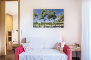 Quarto com uma cama, uma mesa de cabeceira, uma janela e um quadro de árvores na parede.