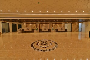 A spacious lobby with a polished marble floor, a central decorative pattern, and a reception desk with a logo. - Accord Chrome (Chennai)