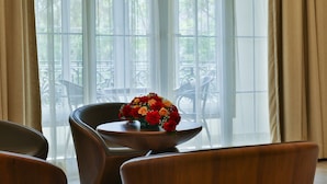 A room with a table and chairs, a window with sheer curtains, and a view of outdoor furniture. - Accord Chrome (Chennai)