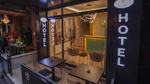 A hotel entrance with a modern design, including a staircase leading to the interior, and a seating area outside with tables and chairs. - Hotel Kale 17 (Çanakkale)