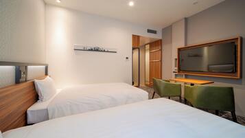 A hotel room with two beds, a desk, a TV, and a cityscape artwork on the wall.