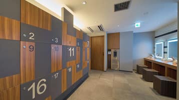 A hotel corridor with numbered lockers, a reception area, and a restroom.