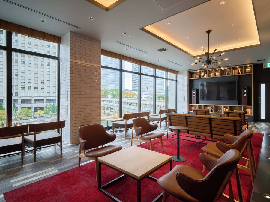 A modern library with large windows, comfortable seating, and a large screen.