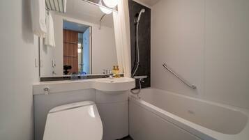 A modern bathroom with a toilet, sink, and bathtub.