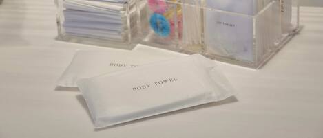 A hotel reception area with clear plastic storage boxes containing various items like towels and toiletries.