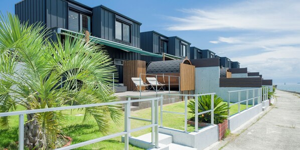 A modern building with a balcony and outdoor seating area.