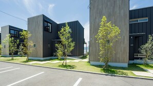 Un bĂątiment moderne dotĂ© dâun toit plat, de grandes fenĂȘtres et dâun parking avec des places dĂ©limitĂ©es.
