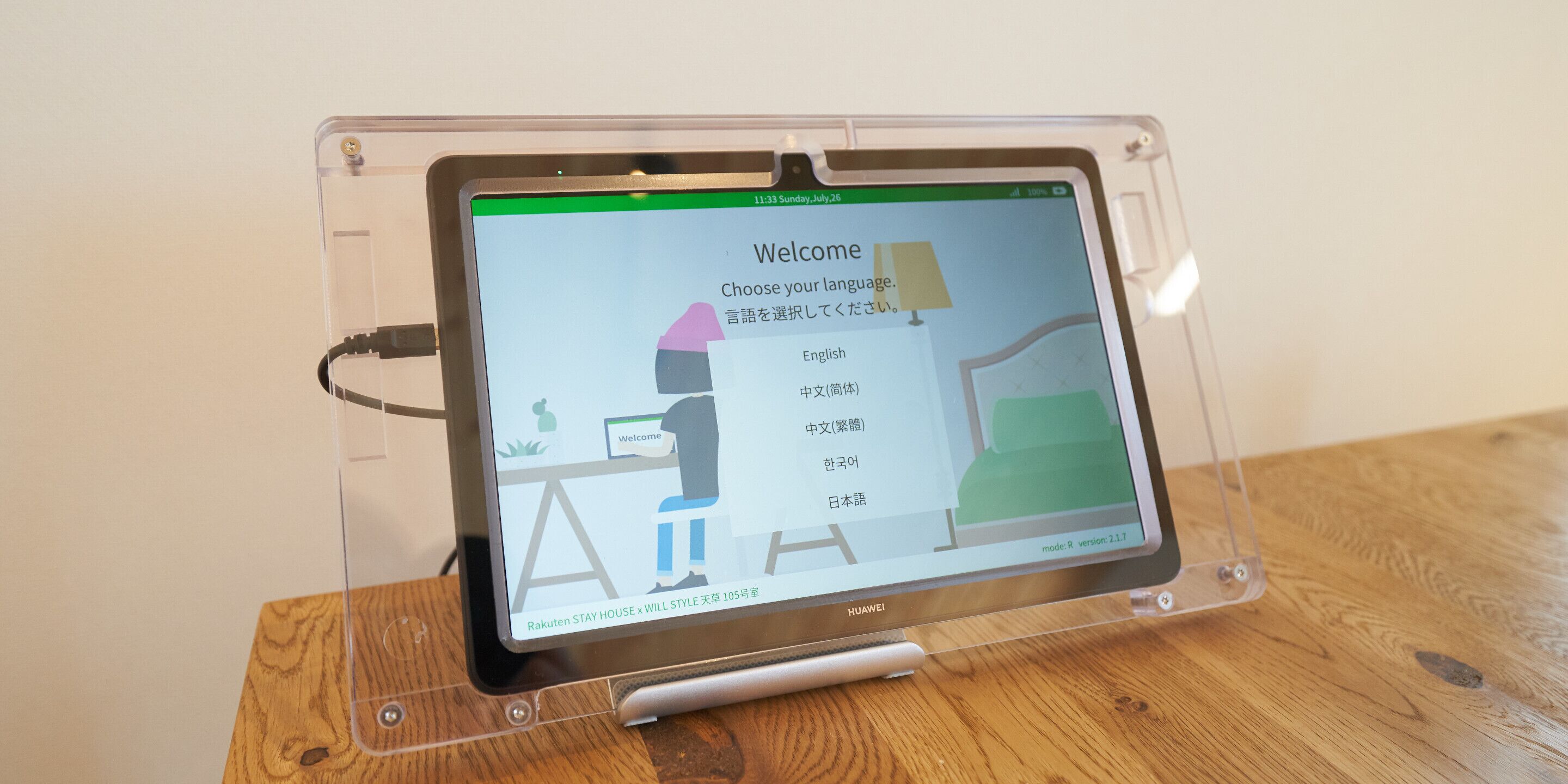 A tablet on a stand displaying a language selection screen with options in English, Chinese, Korean, and Japanese.