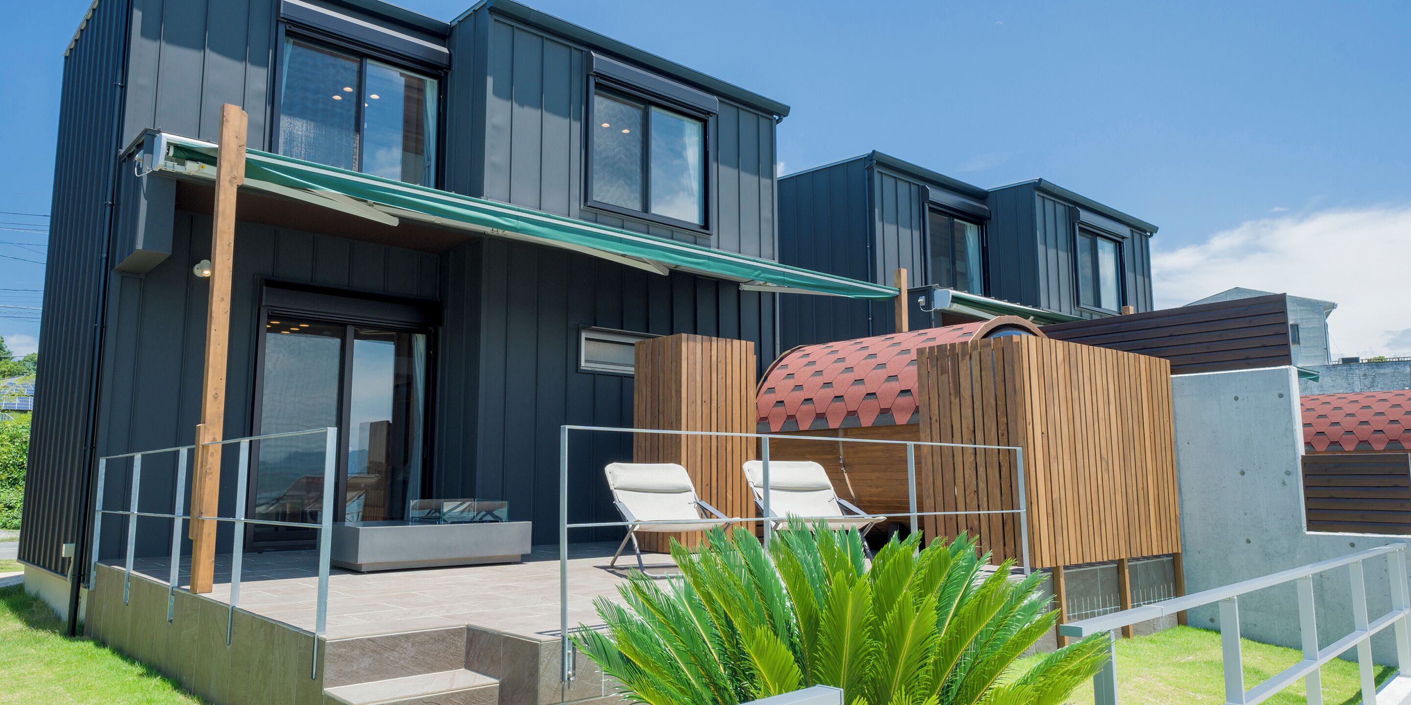 A modern building with a covered outdoor seating area and a pool.