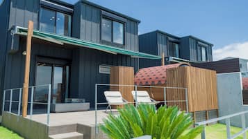A modern building with a covered outdoor seating area and a pool.