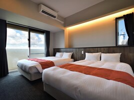 Habitación de hotel con dos camas, un ventanal grande y un equipo de aire acondicionado.