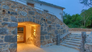 Un bâtiment en pierre avec une porte en bois et des marches menant à l’entrée.