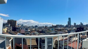 A cityscape with a mix of residential and commercial buildings, including a prominent skyscraper. - Guest House Matsu Bekkan (Osaka)