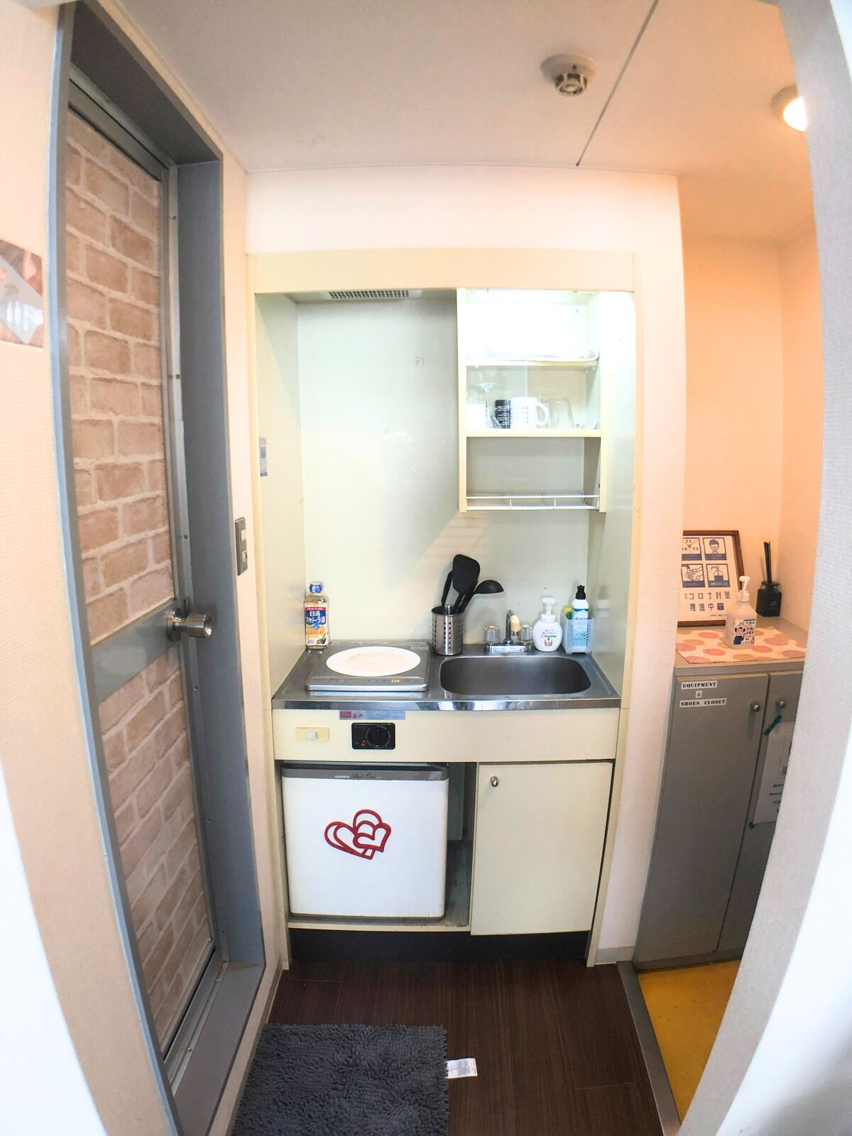 A compact kitchenette with a sink, a small refrigerator, and a microwave.