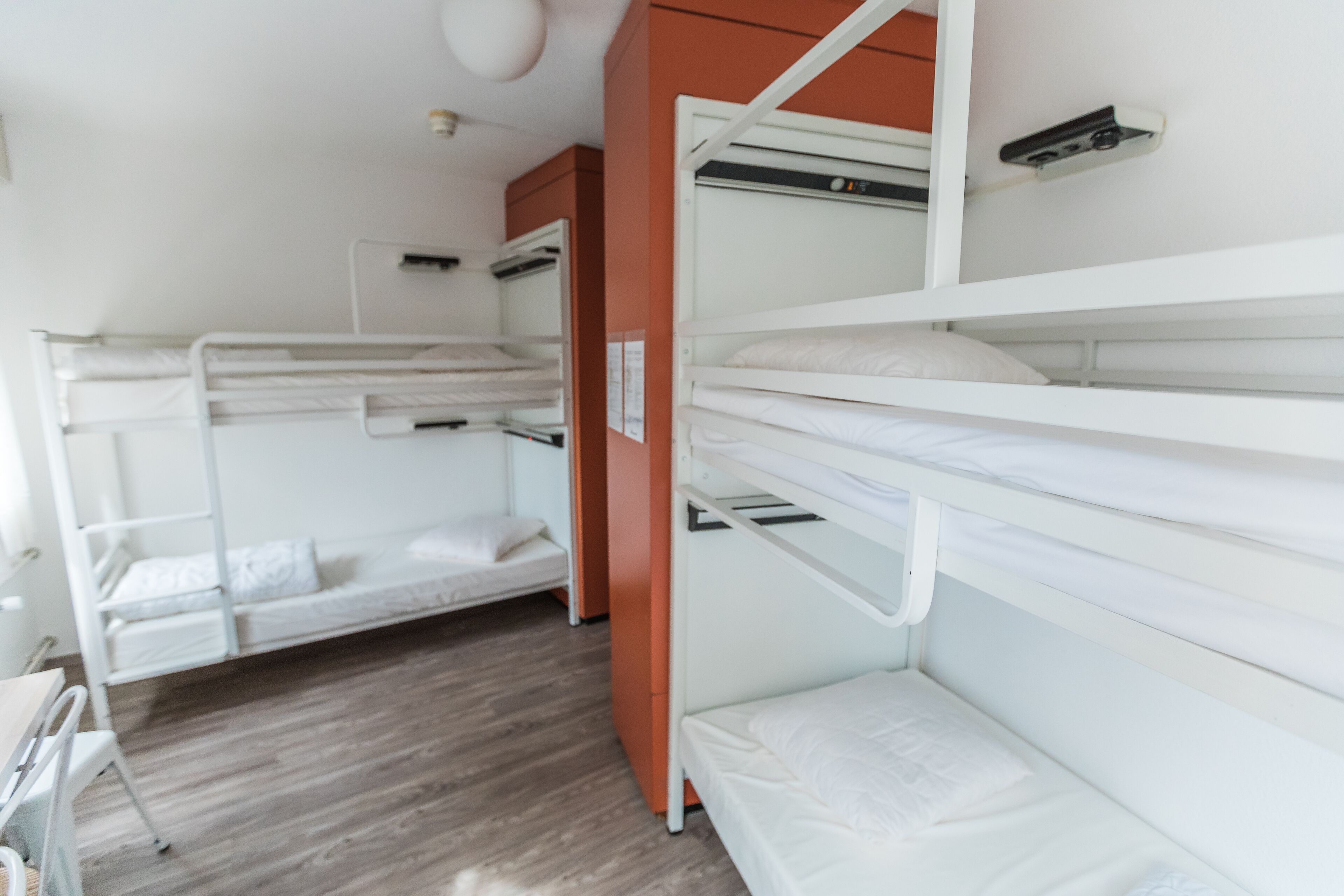 Una habitación con literas, un escritorio y un armario.