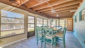 A dining area with a wooden ceiling, large windows, and a table with chairs. - Private Dock: Riverfront Homosassa Home! (Homosassa)