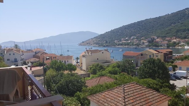 A coastal town with buildings, a view of the sea, and a hilly backdrop. - Moustakis Hotel (Kefalonia)