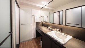 A modern bathroom with a large mirror, a sink, and a towel rack. - Moyen Hotel (Sokcho)