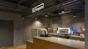 A modern cafe interior with a counter, coffee machines, and a menu display. - Moyen Hotel (Sokcho)