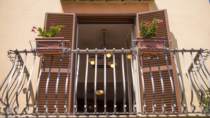 A balcony with metal railings, two potted plants, and a hanging light fixture. - CASA ALESSANDRA in Positano (Positano)