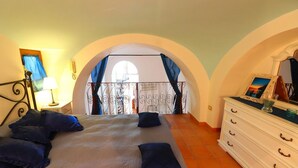 A bedroom with a bed, a dresser, and a balcony. - CASA ALESSANDRA in Positano (Positano)