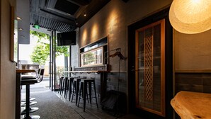 L'intérieur d'un restaurant avec un bar, des tabourets et un comptoir.