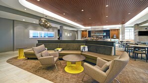 A modern lobby with a curved ceiling, seating area, and a bar. - SpringHill Suites by Marriott St. Paul Arden Hills (Arden Hills)