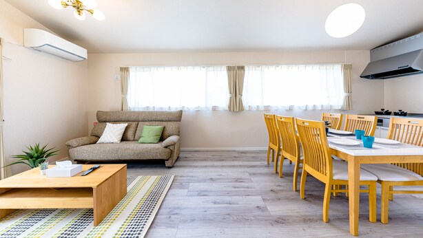 A modern living room with a sofa, coffee table, and dining area with chairs and a table. - Bon Moment B (Fujikawaguchiko)