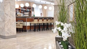 A hotel lobby with a reception desk, bar area, and seating. - Hungarospa Thermal Hotel (Hajduszoboszlo)