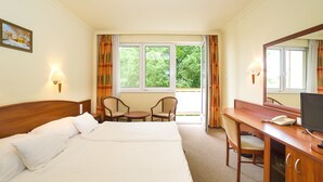 A hotel room with a large bed, a desk with a computer, a chair, and a window with curtains. - Hungarospa Thermal Hotel (Hajduszoboszlo)