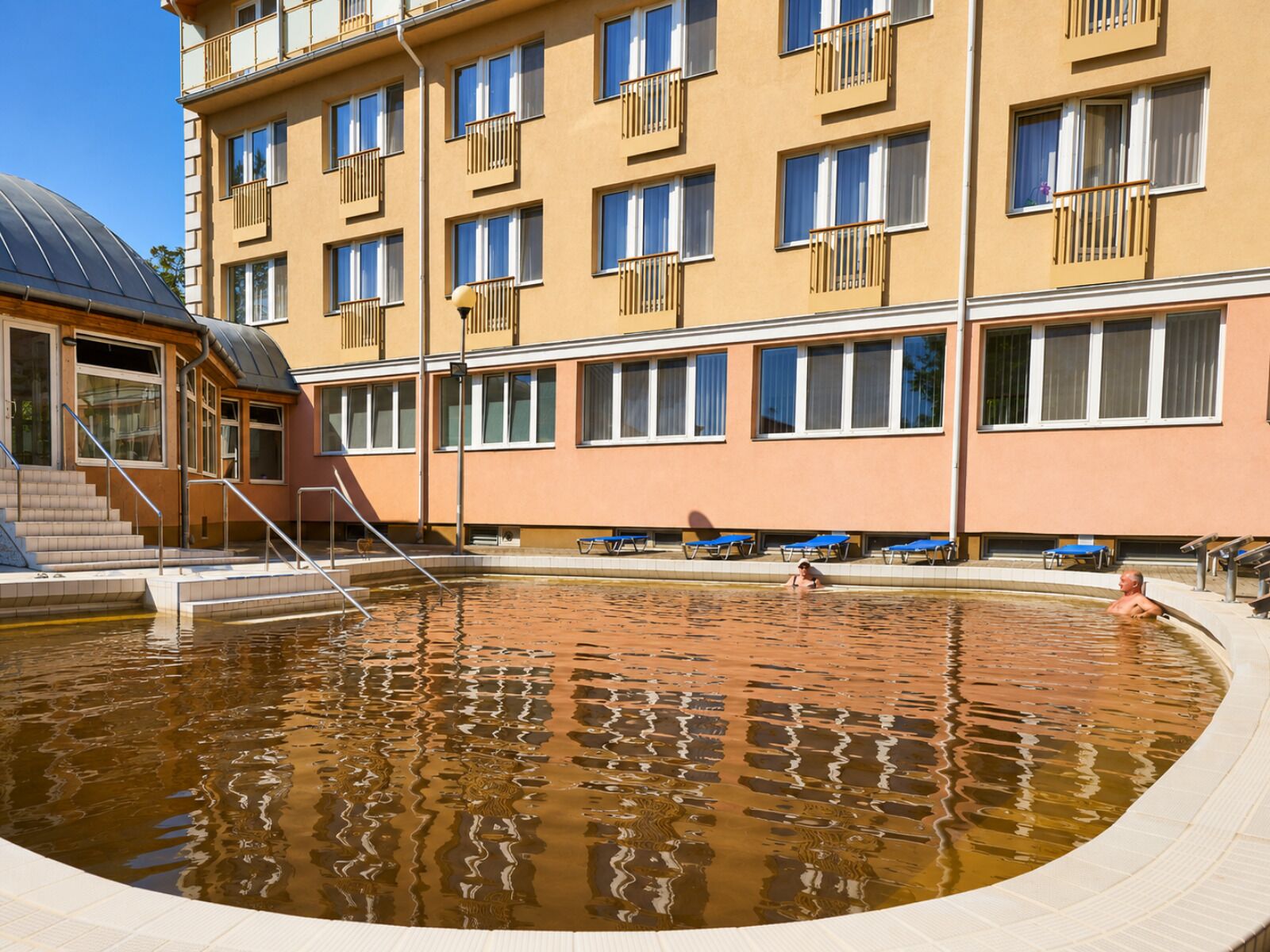 Un hôtel doté d’une piscine, de plusieurs balcons et d’une entrée abritée.