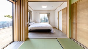 Une chambre d’hôtel avec un lit, une vue sur la plage et une porte coulissante donnant sur une autre pièce.