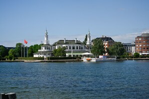 A riverside view with a historic building, a boat, and a modern building across the water. - Lake - Pleasant 2-Bdr Apt in City Center (København)