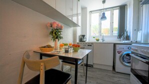 Een koffiezetapparaat/waterkoker, een koelkast, een oven, een kookplaat