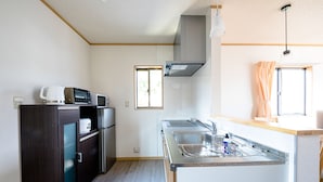 Una cocina compacta equipada con microondas, refrigerador y lavamanos.