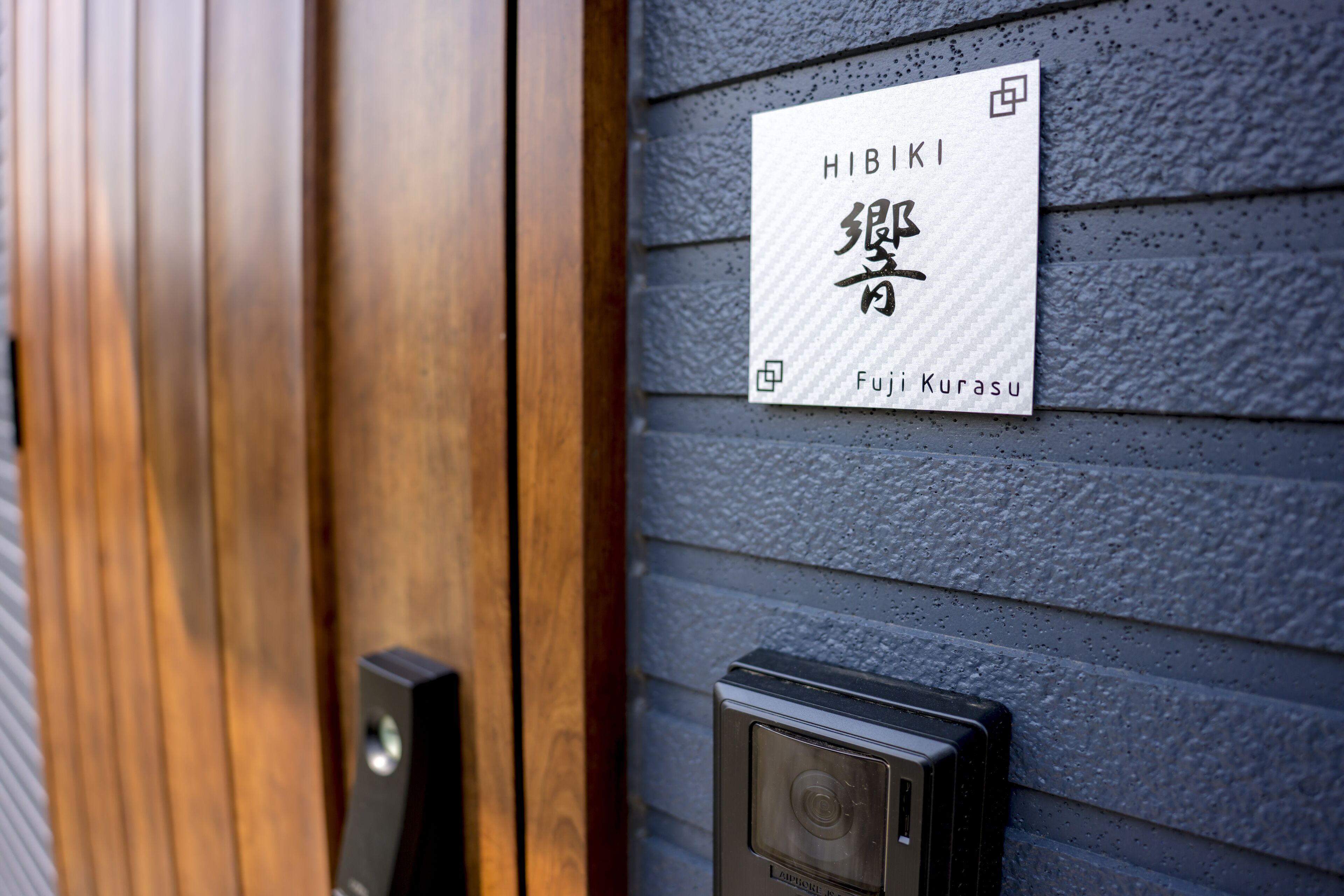 A door with a sign that reads "HIBIKI" and "Fujii Kurasu".