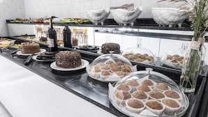 A buffet with various desserts including cakes and muffins, and a bottle of wine. - Side Spring Hotel (Manavgat)