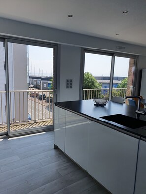 Enjoy a kitchen with a sink, large windows, and a balcony view.