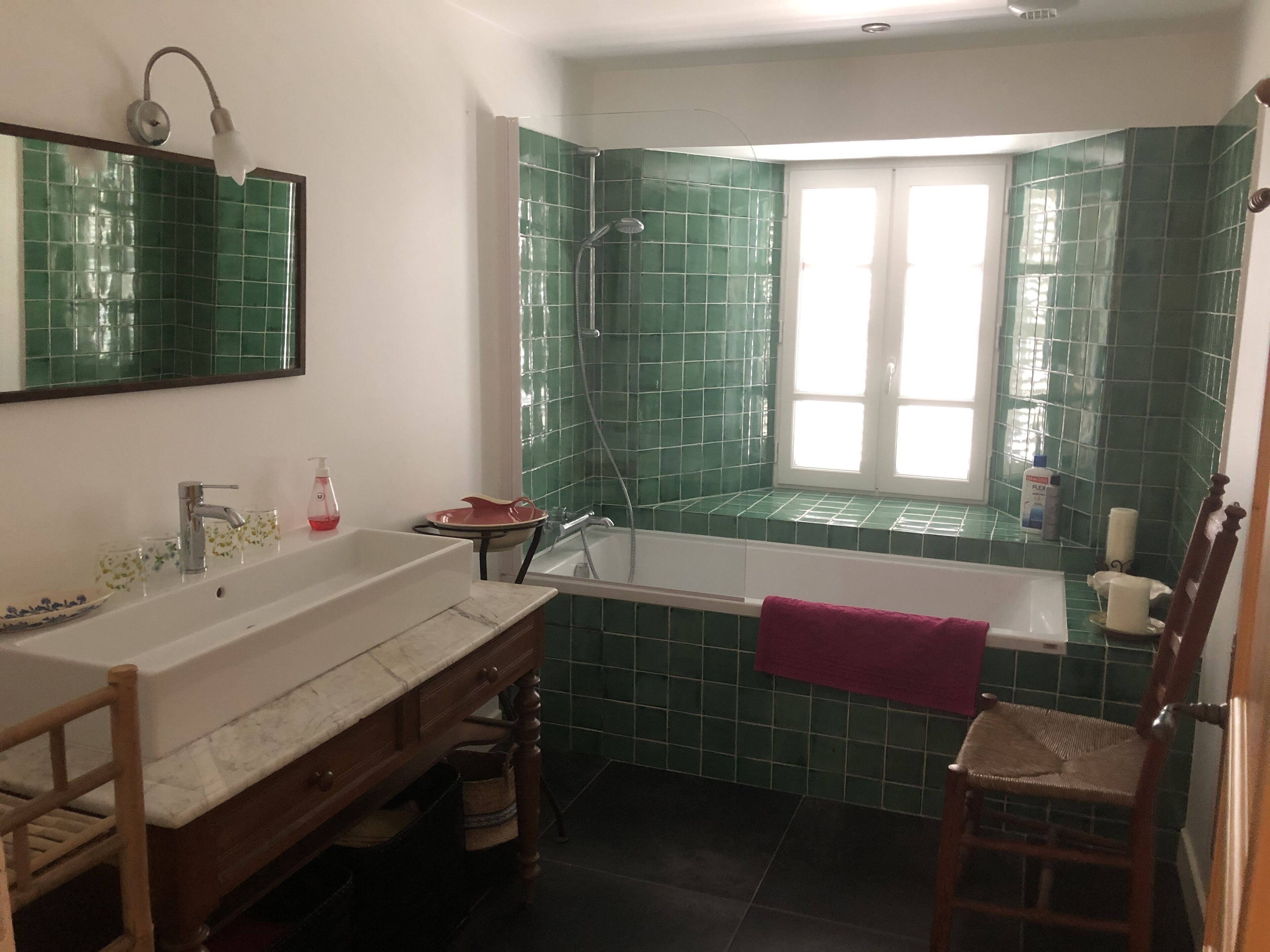 Un bagno con una grande vasca, un lavandino e uno specchio.
