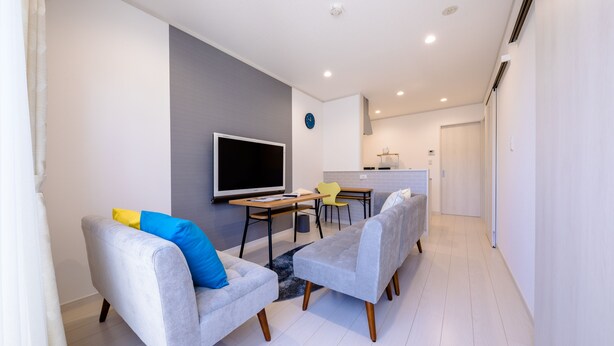 A modern living room with grey sofas, a flat-screen TV, and a dining area with a table and chairs. - Fuga-A (Fujikawaguchiko)