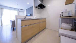 A modern kitchen with a central island, a built-in oven, and a coffee machine. - Fuga-A (Fujikawaguchiko)