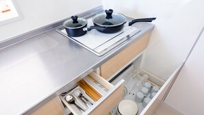 A kitchen with a built-in stove, two pots, and a drawer with utensils and dishes. - Fuga-A (Fujikawaguchiko)