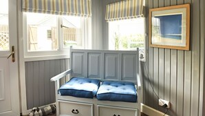 A room with a white bed with blue cushions, a window with striped valance, and a framed picture on the wall. - Ochil Cottage In Bannockburn, Close to Stirling (Stirling)