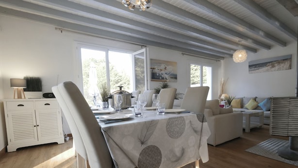En matplats med ett bord för fyra personer, en soffa och en dekorativ golvlampa.