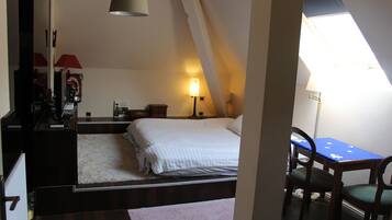 Une chambre avec un lit, un bureau et une chaise. Une fenêtre laisse entrer la lumière naturelle.
