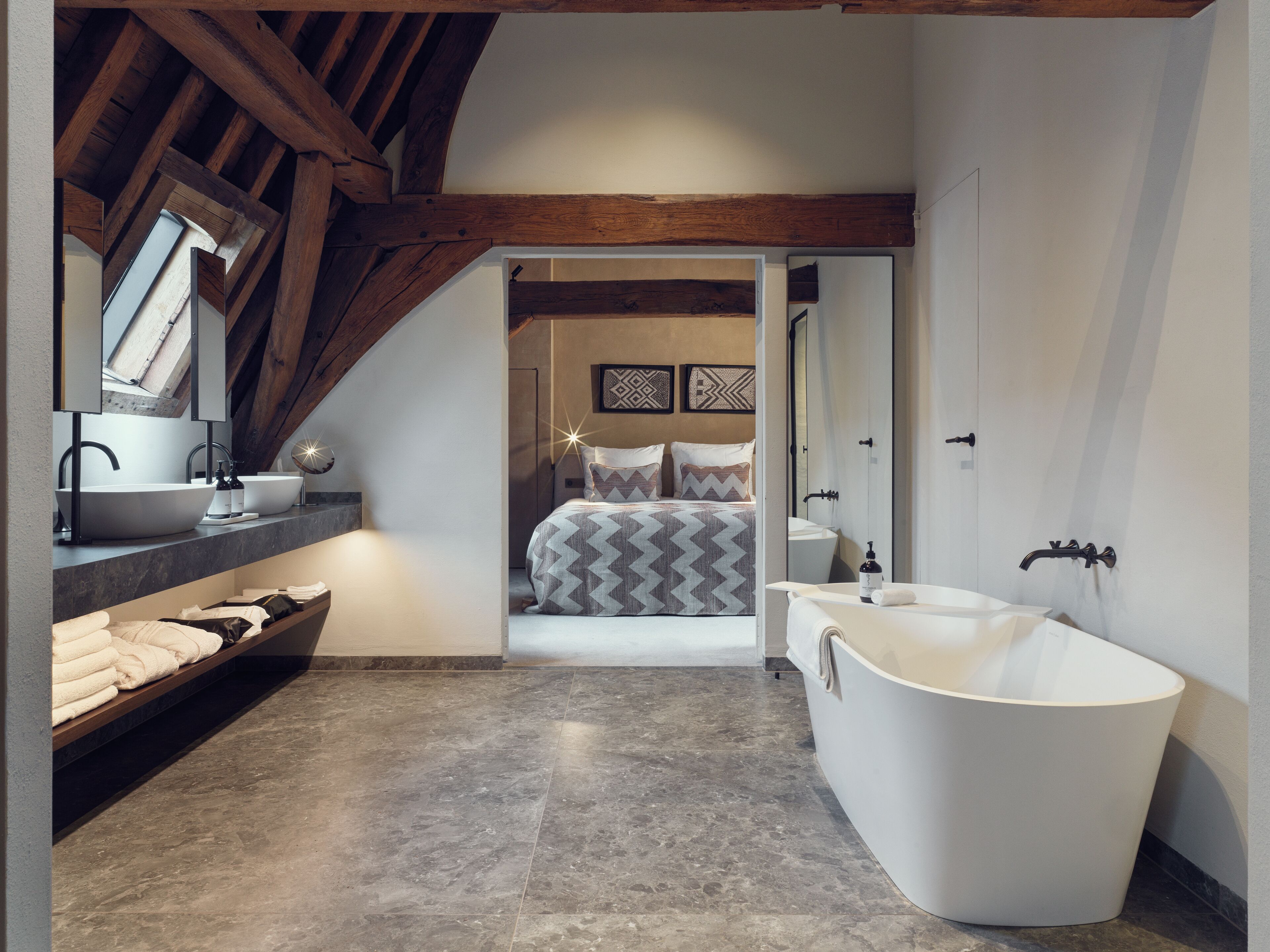 A modern bathroom with a freestanding bathtub, a large mirror, and a vanity with a sink.