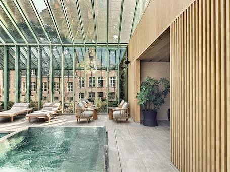 Una piscina techada, sillones reclinables de piscina