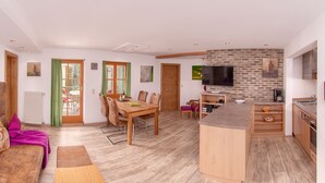 A modern living space with a dining area, kitchen, and seating area. - Zinnkopf, Ferienwohnung , Terrasse, Küche Extra, 3 Schlaf- und 1 Wohnzimmer, max 6 Pers, Wlan (Ruhpolding)