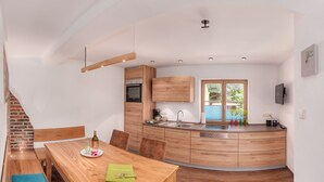 A modern kitchen with wooden cabinets, a built-in oven, and a large window. - Zinnkopf, Ferienwohnung , Terrasse, Küche Extra, 3 Schlaf- und 1 Wohnzimmer, max 6 Pers, Wlan (Ruhpolding)